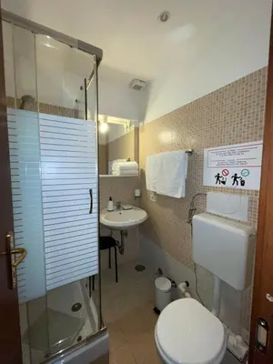 a small bathroom with a toilet and a sink at Guest House Meret in Rome