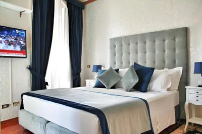 a bedroom with a large white bed with blue pillows at Di Rienzo Pantheon Palace in Rome