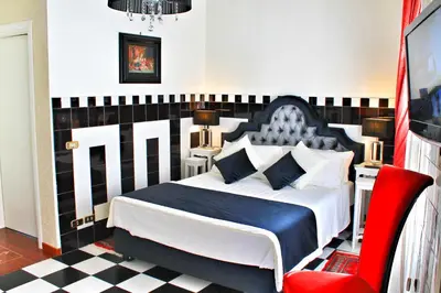 a bedroom with a large bed and a red chair at Di Rienzo Pantheon Palace in Rome