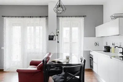 a living room with a table and a red couch at Scarfoglio Apartment, 4 persone, 2 camere, balcone, Wi-Fi, Stazione Tiburtina in Rome
