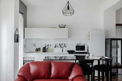 a living room with a red couch and a kitchen at Scarfoglio Apartment, 4 persone, 2 camere, balcone, Wi-Fi, Stazione Tiburtina in Rome