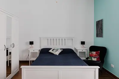 a bedroom with a bed and two white tables at Scarfoglio Apartment, 4 persone, 2 camere, balcone, Wi-Fi, Stazione Tiburtina in Rome