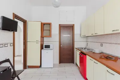 a kitchen with white cabinets and a white refrigerator at Casa Flo in Rome