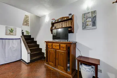 a living room with a television and a staircase at Charming Apartment with Garden, Parking & Metro in Rome