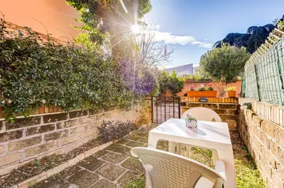a patio with a table and chairs in a backyard at Charming Apartment with Garden, Parking & Metro in Rome