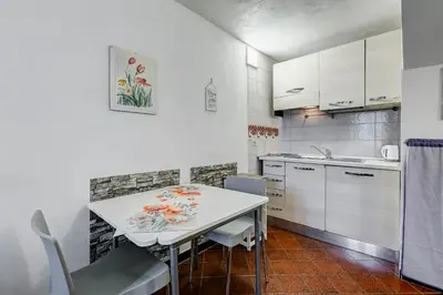 a small kitchen with a white table and chairs at Charming Apartment with Garden, Parking & Metro in Rome