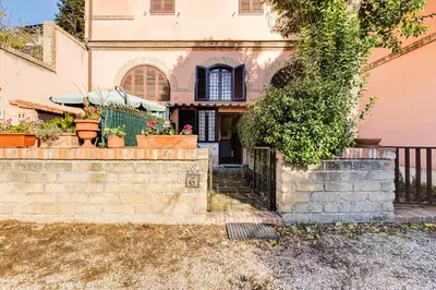 a house with a fence and some plants at Charming Apartment with Garden, Parking & Metro in Rome
