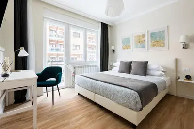 a white bedroom with a bed and a desk at Momo Central Rome 2 in Rome