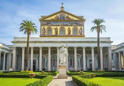 a building with a statue in front of it with palm trees at Erossuite GuestHouse in Rome