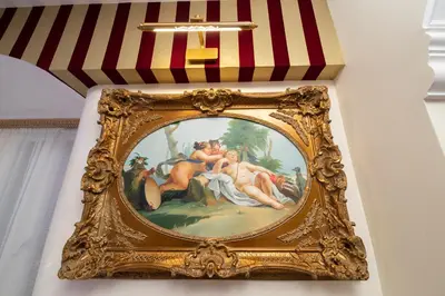 a painting in a gold frame hanging on a wall at Erossuite GuestHouse in Rome