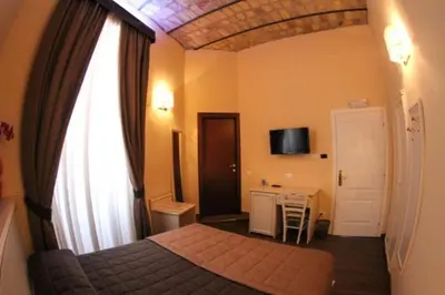 a bedroom with a bed and a window and a desk at La Favola di San Pietro in Rome