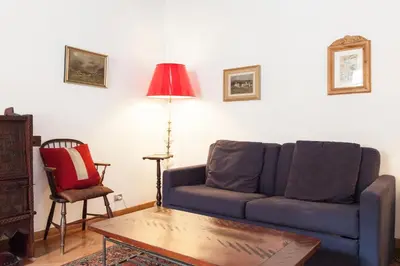 a living room with a blue couch and a table at Libri Flat in Rome