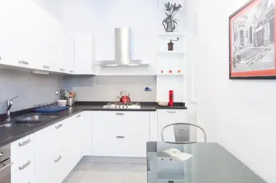a white kitchen with white cabinets and a sink at Libri Flat in Rome