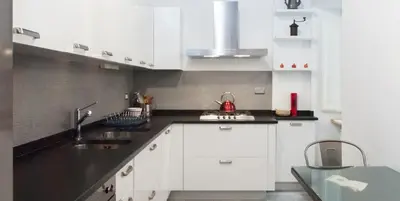 a kitchen with white cabinets and a black counter top at Libri Flat in Rome