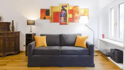 a living room with a blue couch with yellow pillows at Lovely Maisonette Trastevere in Rome