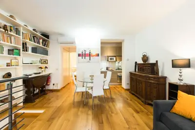 a dining room and living room with a table and chairs at Lovely Maisonette Trastevere in Rome