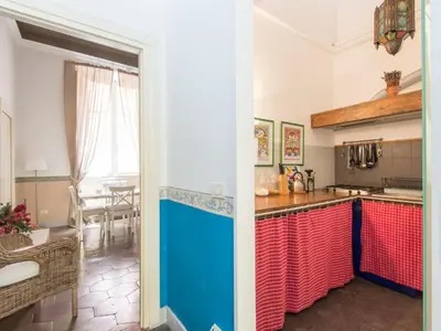a kitchen with red and blue cabinets and a table at Apartment Romantico by Interhome in Rome