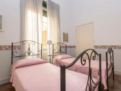 two beds in a bedroom with pink sheets and a window at Apartment Romantico by Interhome in Rome