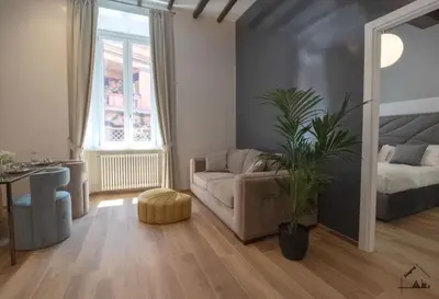 a living room with a couch and a plant at Charme apartment with Spa in Piazza del Popolo in Rome