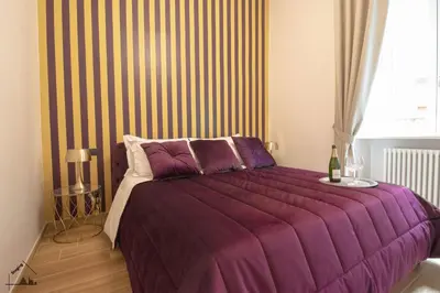 a bedroom with a purple bed with a striped wall at Charme apartment with Spa in Piazza del Popolo in Rome