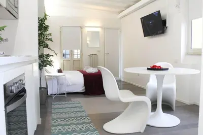a white room with a table and a bed at Bright Cozy Studio Trastevere in Rome
