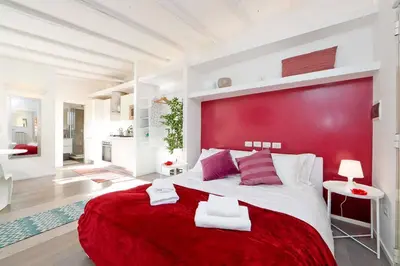 a bedroom with a red headboard and a large bed at Bright Cozy Studio Trastevere in Rome