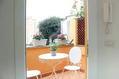 a balcony with a table and two chairs and a window at Bright Cozy Studio Trastevere in Rome