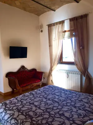 a bedroom with a bed and a window with a couch at SUPERATTICO SUL COLOSSEO in Rome
