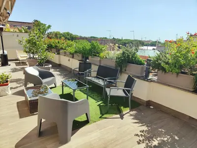 a balcony with chairs and tables and potted plants at SUPERATTICO SUL COLOSSEO in Rome