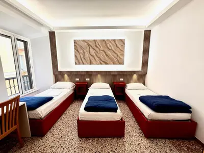 two beds in a room with two windows at Legend R.G. in Rome