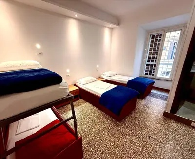 a bedroom with a bed and blue curtains and a table at Legend R.G. in Rome
