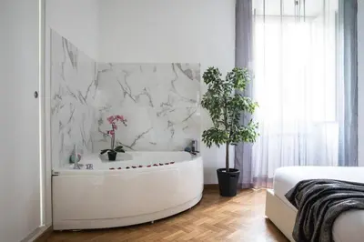 a white bathroom with a tub with plants in it at Silver Luxury Jacuzzi Suite Trastevere in Rome