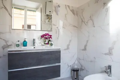 a white bathroom with a sink and a mirror at Pink Intimate Jacuzzi Suite Trastevere in Rome