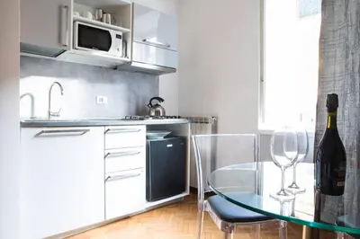 a kitchen with a glass table and a bottle of wine at Pink Intimate Jacuzzi Suite Trastevere in Rome
