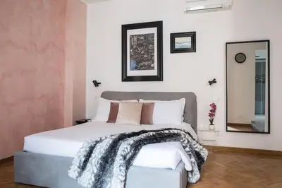 a bedroom with a white bed and a mirror at Pink Intimate Jacuzzi Suite Trastevere in Rome