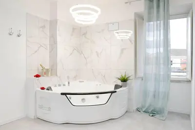 a white bathroom with a tub and a shower at White Panoramic Jacuzzi Suite Trastevere in Rome