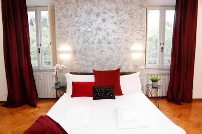 a bedroom with a large white bed with red pillows at Black Enchanting Jacuzzi Suite Trastevere in Rome