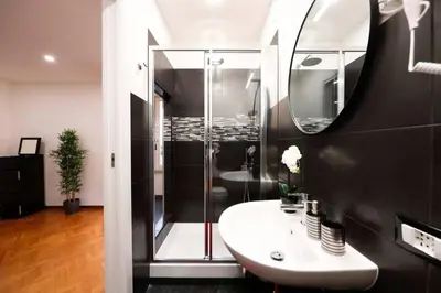 a bathroom with a shower and a sink and a mirror at Black Enchanting Jacuzzi Suite Trastevere in Rome