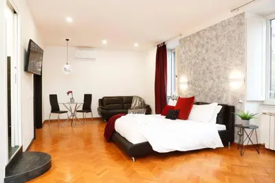 a bedroom with a large bed and a couch at Black Enchanting Jacuzzi Suite Trastevere in Rome