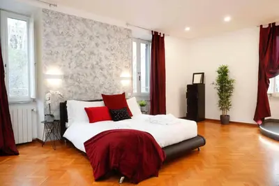 a bedroom with a large white bed with red pillows at Black Enchanting Jacuzzi Suite Trastevere in Rome