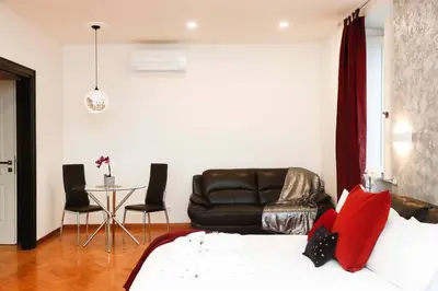 a living room with a bed and a couch and a table at Black Enchanting Jacuzzi Suite Trastevere in Rome