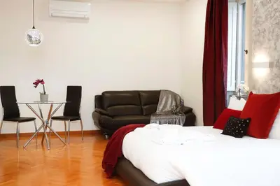 a bedroom with a bed and a couch and a table at Black Enchanting Jacuzzi Suite Trastevere in Rome
