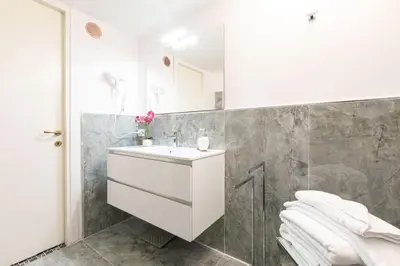 a bathroom with a white sink and a mirror at Campo dè Fiori Detached Apartment Eligio - Top Collection in Rome