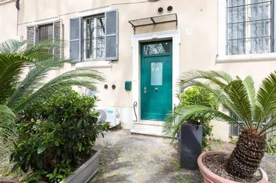 a green door on a house with palm trees at Campo dè Fiori Detached Apartment Eligio - Top Collection in Rome