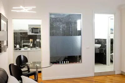 a living room with a glass table and a kitchen at Pantheon Amazing Jacuzzi Suite in Rome