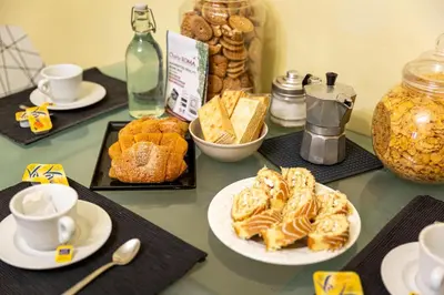 a table topped with plates of pastries and cups of coffee at Roma family apartment in Rome