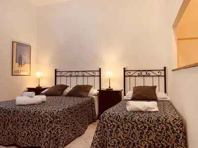 two beds sitting next to each other in a bedroom at Roma family apartment in Rome