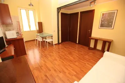 a living room with a table and a wooden floor at Roma family apartment in Rome