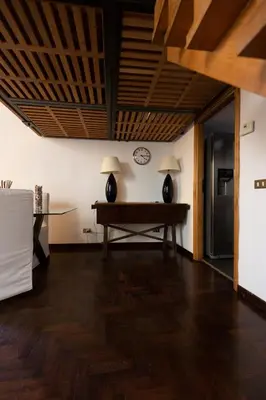 a living room with a table and a clock on the wall at Rufina Apartment in Rome