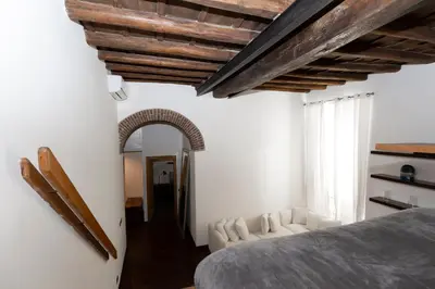 a bedroom with white walls and a bed and a couch at Rufina Apartment in Rome